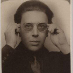 Portrait of André Breton holding eyeglasses, circa 1923.